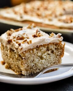 Slice of cake on white plate with fork in front.