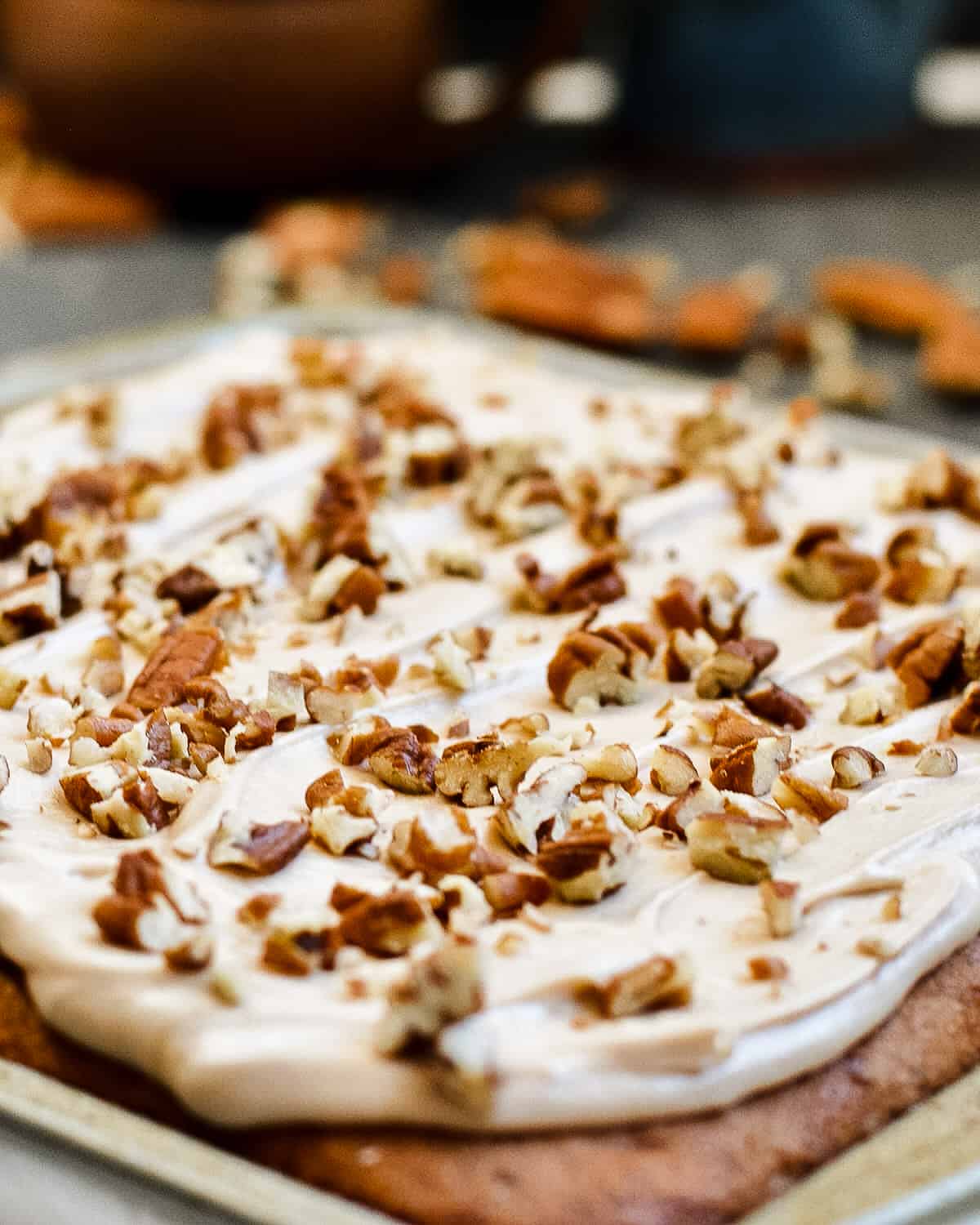 Up close of pecans on top of maple frosting and pecan cake