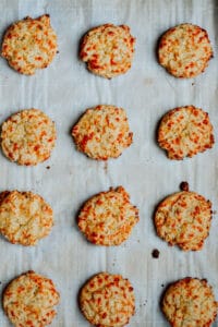 Fully baked Italian cheese and herb biscuits on a baking sheet.